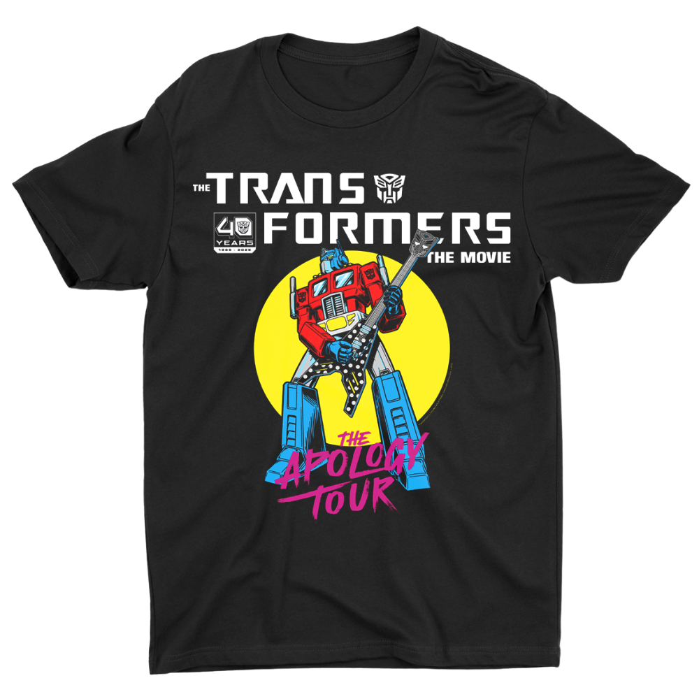 A black short-sleeve crewneck t-shirt featuring a colorful graphic print of Optimus Prime from Transformers The Movie with a yellow circular background and pink text reading 'The Apology Tour'.