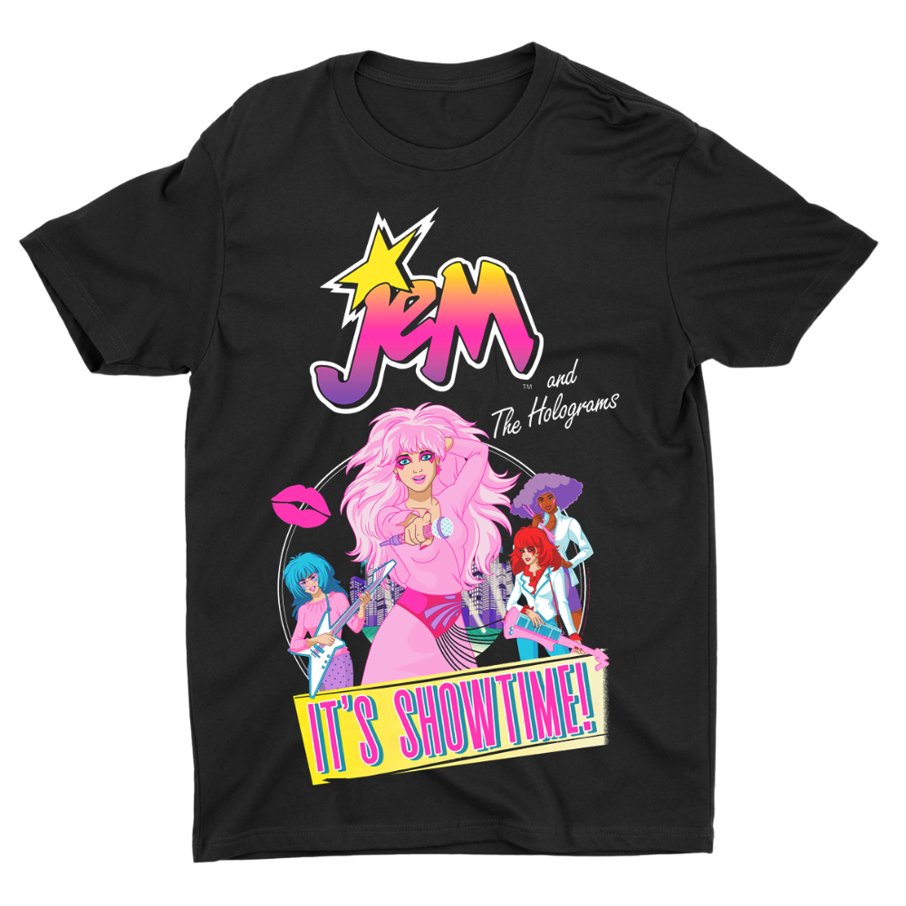 A black short-sleeve graphic t-shirt featuring a colorful retro-style print of 'JEM and The Holograms' with a pink-haired character and the text 'IT'S SHOWTIME!' on a white background.